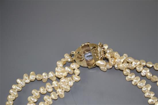 A double strand cultured baroque pearl necklace with yellow metal and garnet ? cluster clasp and one other simulated pearl necklace.